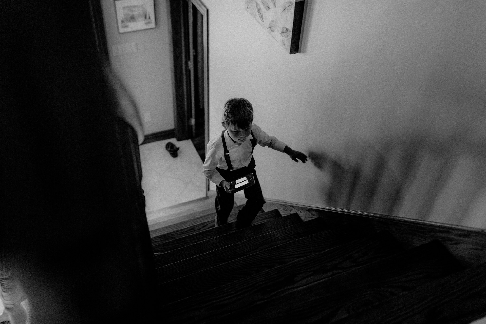 Ring Bearer climbing stairs as groom gets ready for wedding