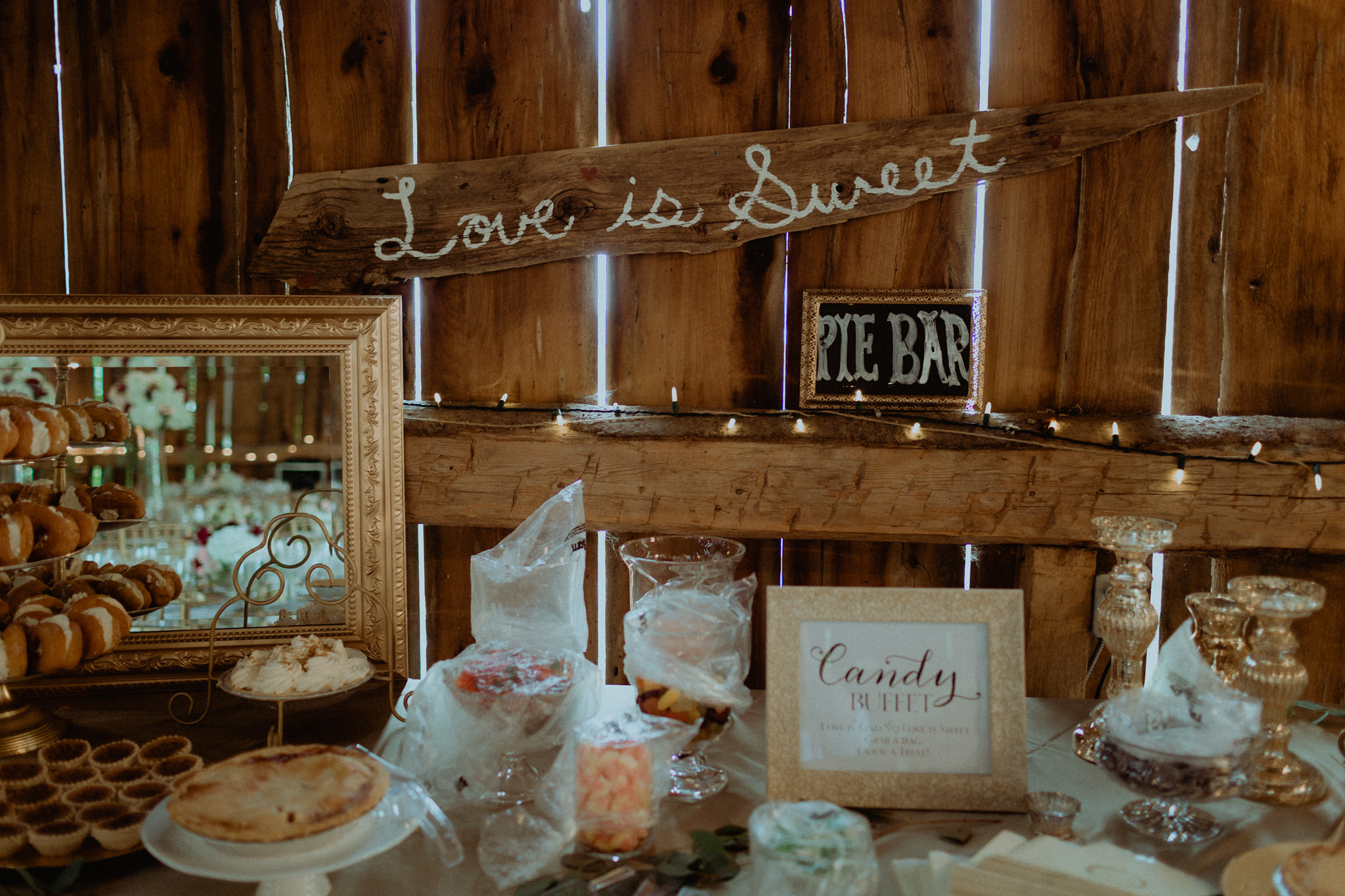 Love is sweet sign at candy bar in century barn wedding venue reception space
