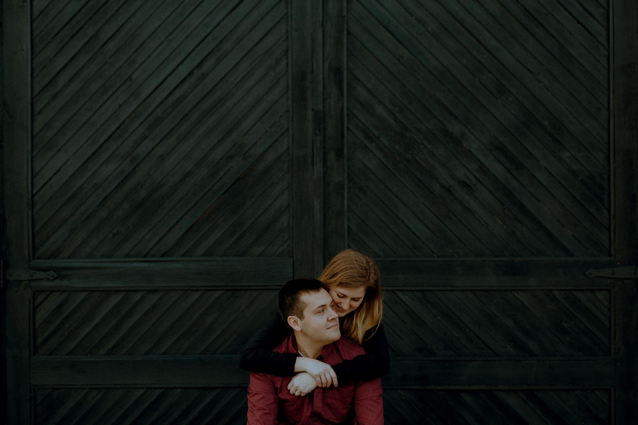 cozy couple in front of industrial barn doors