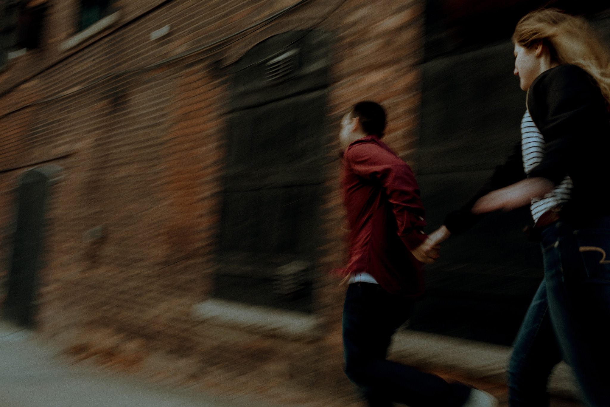finance leads his girl while running past industrial building