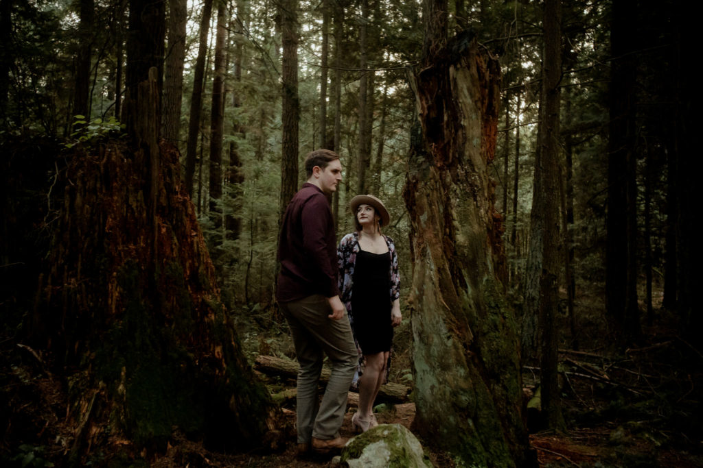 a couple standing in the forest of Pacific Spirit Regional Park